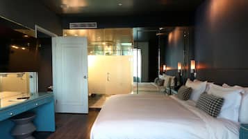 Et moderne hotelværelse med en stor seng, eget badeværelse og et skrivebord med spejl.