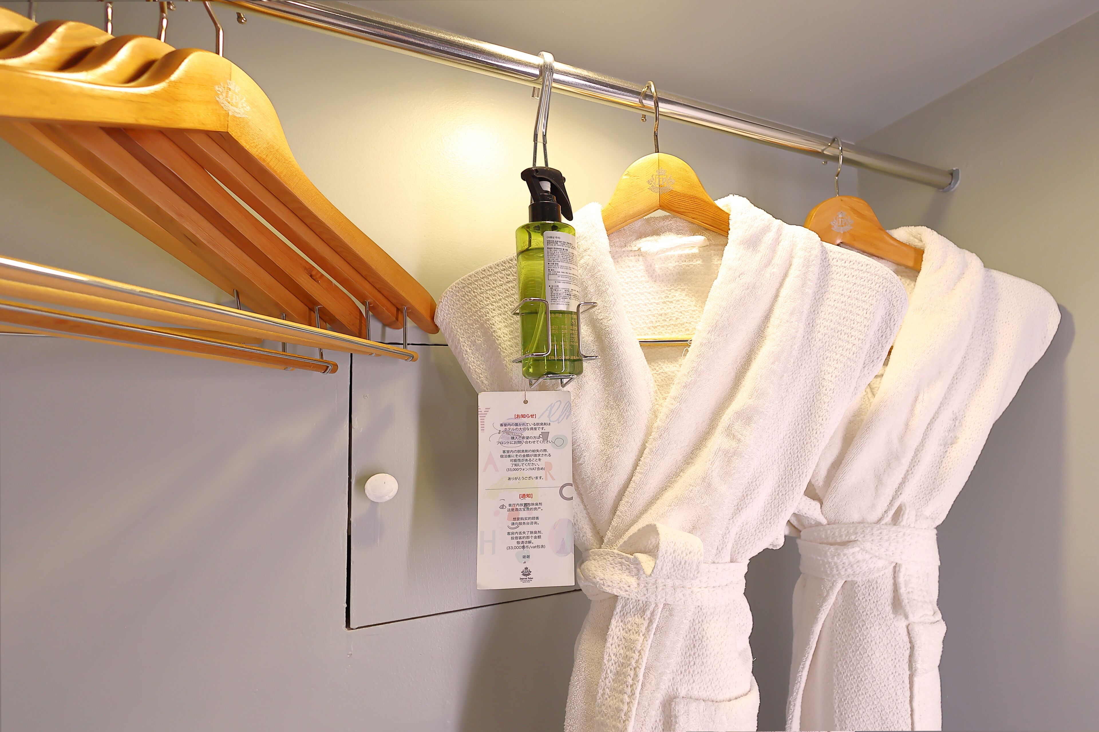 A bathroom with a towel rack holding a white towel and a bottle of shampoo.