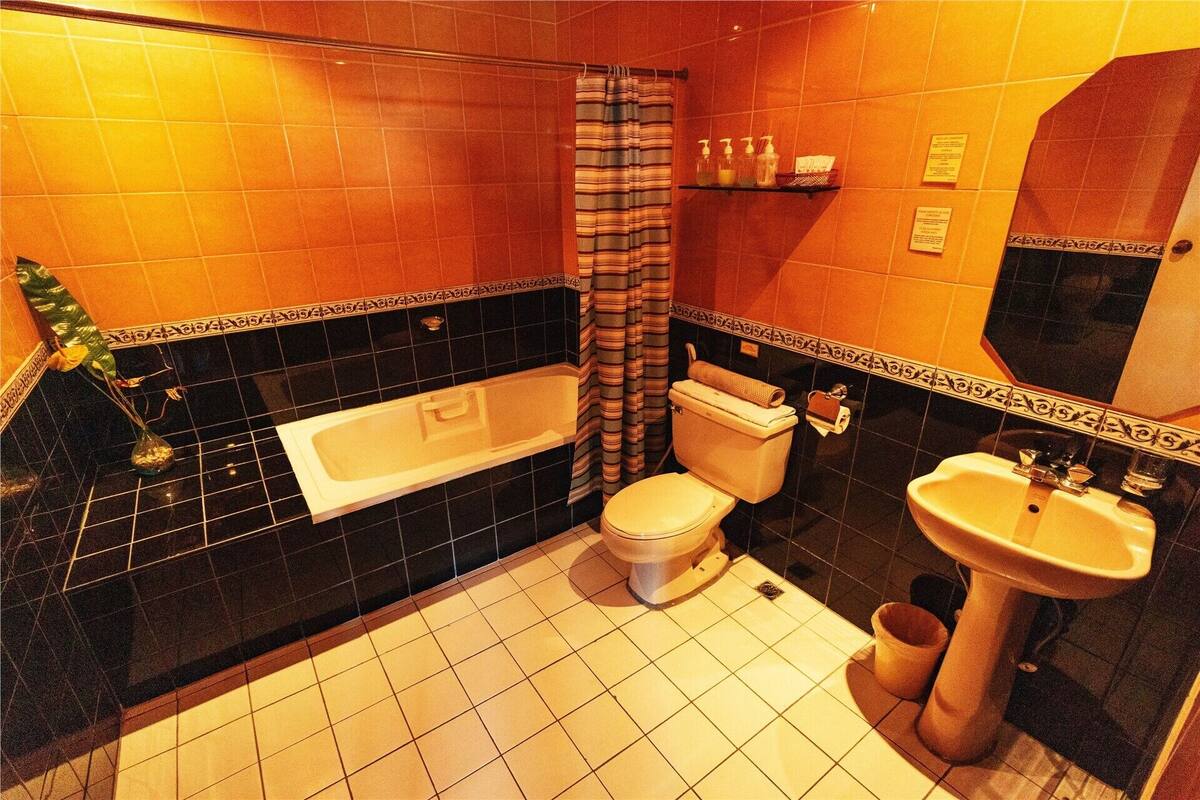 A bathroom with a bathtub, toilet, sink, and a shower curtain.