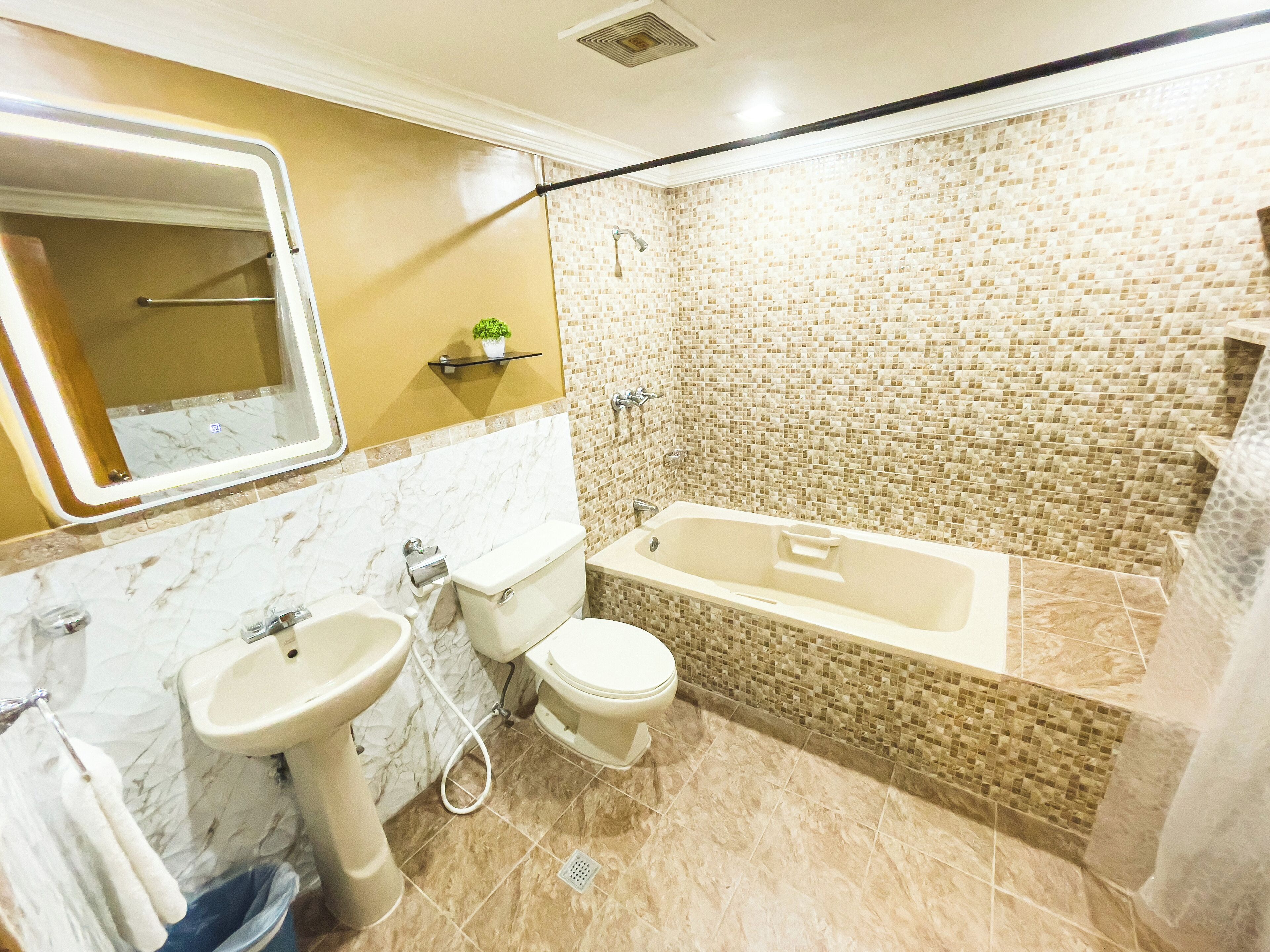 Ein Badezimmer mit Badewanne, Toilette, Waschbecken und Duschbereich.
