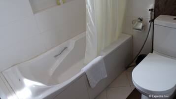 A bathroom with a bathtub, toilet, and shower.