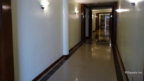 A hotel corridor with light fixtures along the walls and a tiled floor. - Hotel Fleuris Palawan (Puerto Princesa)