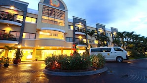A hotel with a curved facade, multiple balconies, and a central entrance with a fountain. - Hotel Fleuris Palawan (Puerto Princesa)