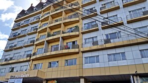Un hôtel à plusieurs étages doté de balcons, une enseigne indiquant « Burnham Suites » et une autre indiquant « Sunflower Cafe ».