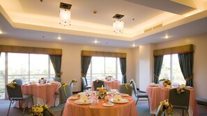Un espace repas avec des tables rondes, des chaises et des centres de table floraux.