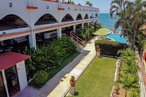 A hotel with a pool, outdoor seating, and a view of the ocean. - Casa Sun and Moon (Zihuatanejo)