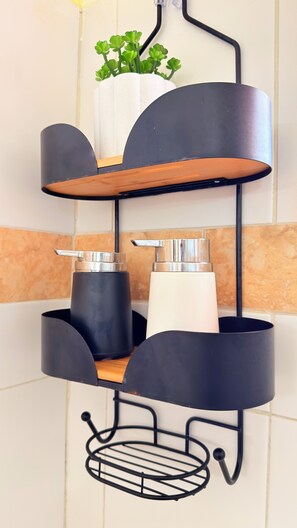 A black metal shelf unit with a wooden shelf and a hanging metal basket. - Casa Sun and Moon (Zihuatanejo)
