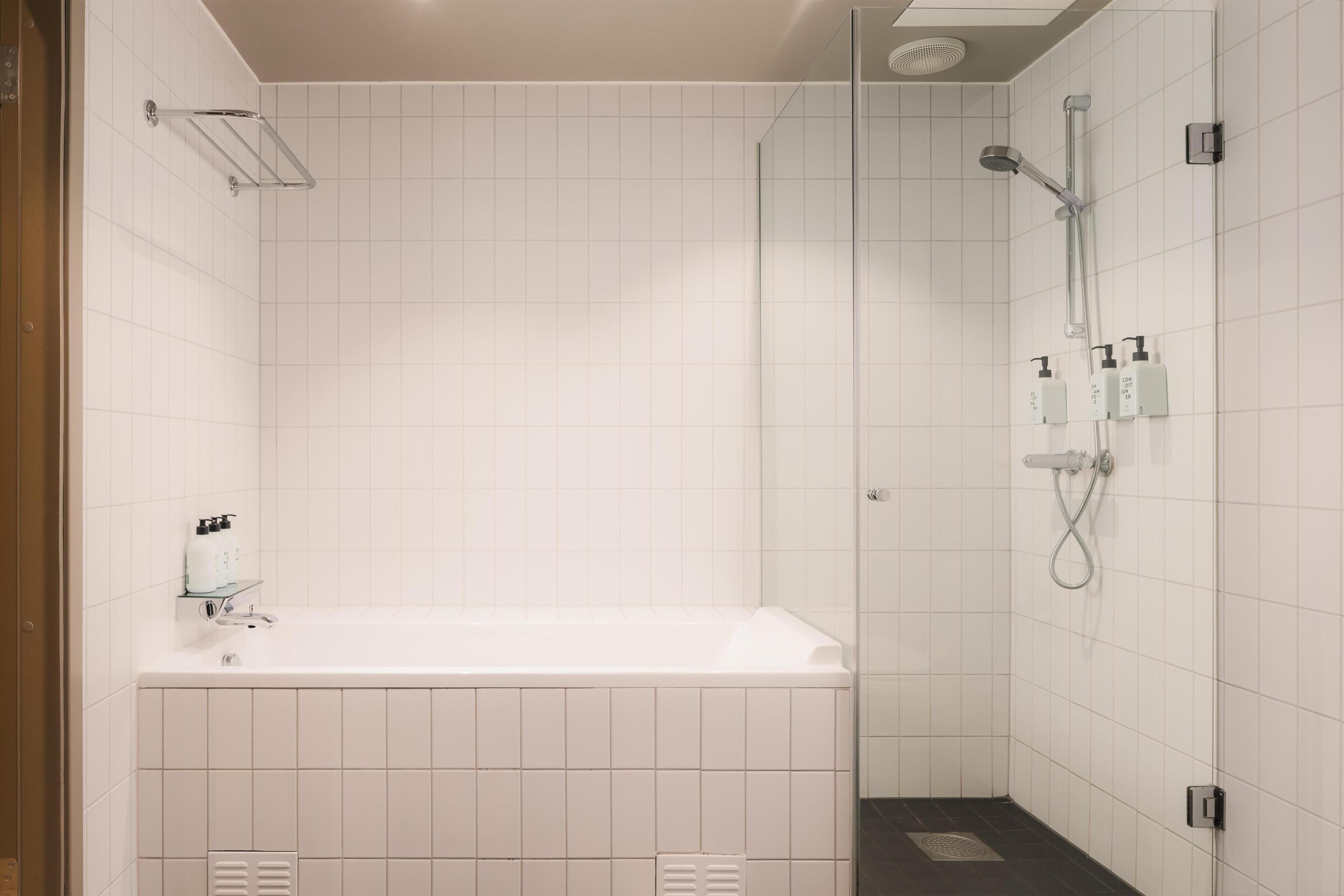 A bathroom with a bathtub, a shower, and a glass-enclosed shower area.