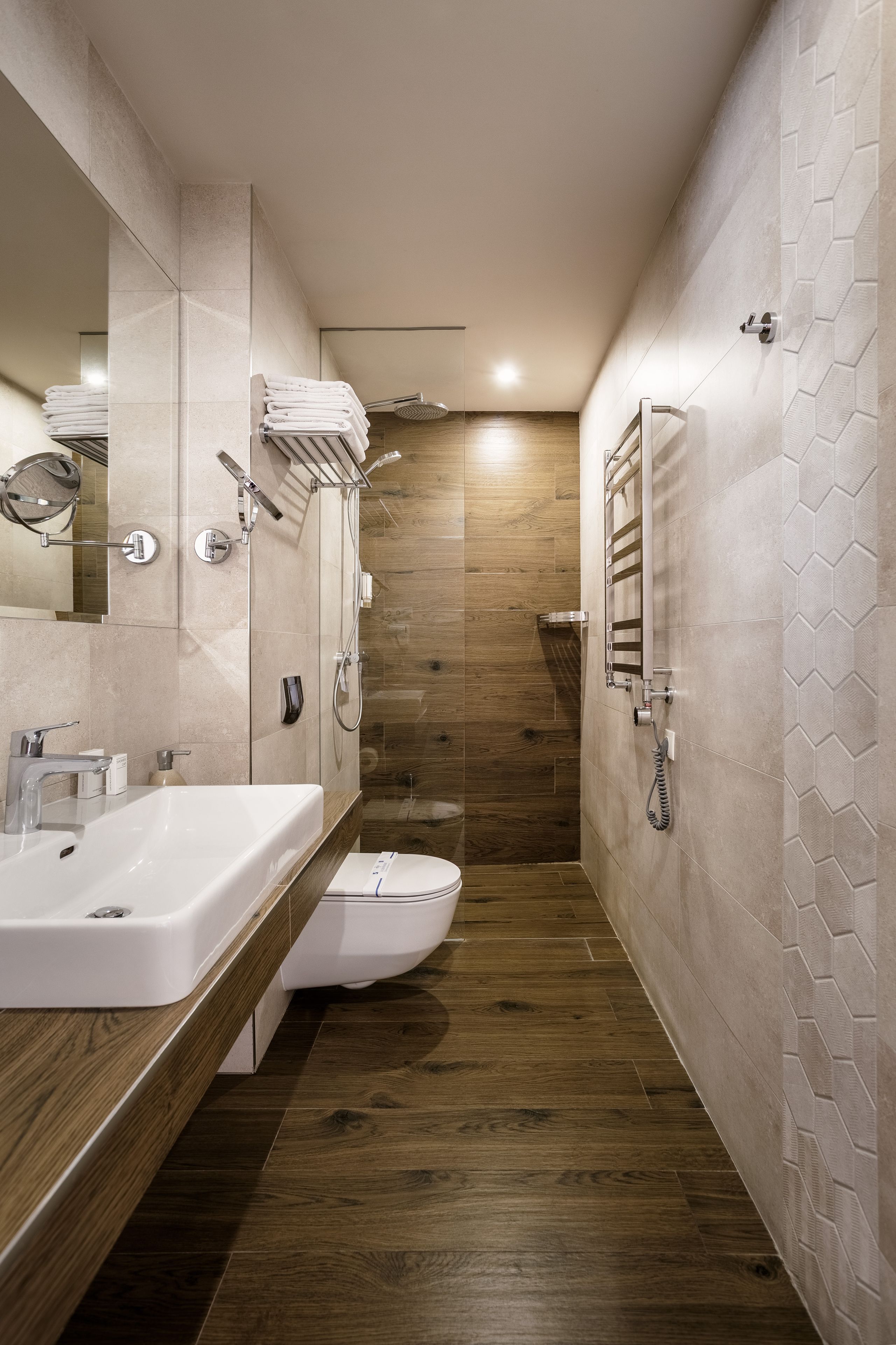Een moderne badkamer met twee wasbakken, toilet en douche.