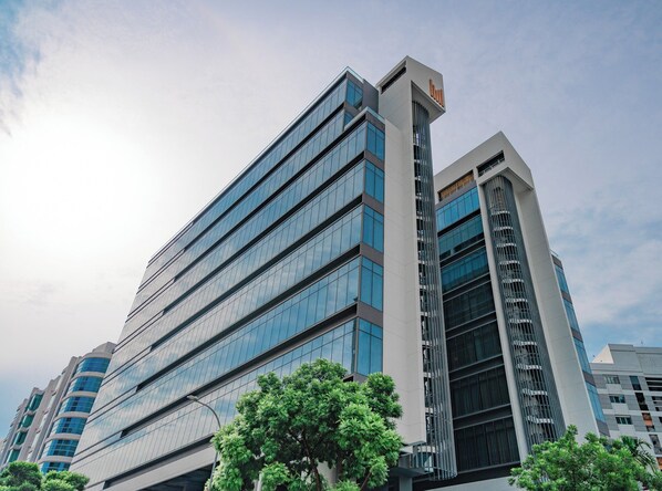 A modern high-rise building with multiple glass windows and a prominent vertical structure. - Studio M Hotel Singapore (Singapore)