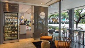 A modern interior with a wine display, seating area, and a view of the street. - Studio M Hotel Singapore (Singapore)