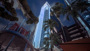 A high-rise hotel with a modern glass facade, palm trees, and a view of the sky. - Studio M Hotel Singapore (Singapore)