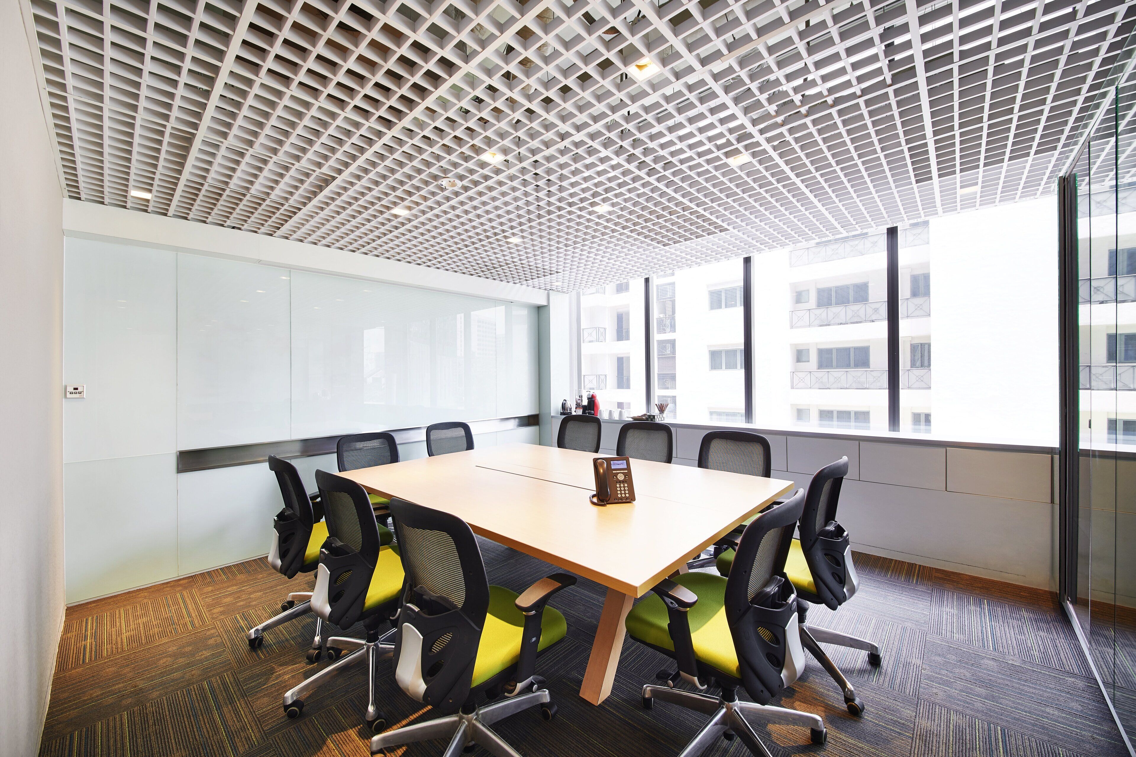 A conference room with a large table, chairs, and a modern ceiling design.