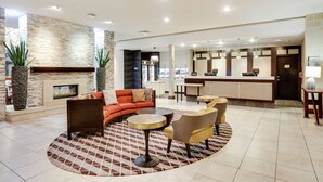 A modern lobby with a fireplace, seating area, and a reception desk. - Homewood Suites Dallas Allen (Allen)