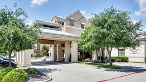 A hotel entrance with a covered walkway, clear signage, and landscaped surroundings. - Homewood Suites Dallas Allen (Allen)