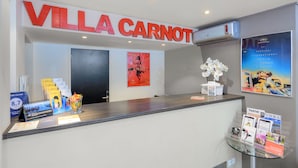 A reception desk with a sign reading "VILLA CARNOT" and a calendar on the left. - Appart’Hôtel La Villa Carnot Cannes (Cannes)