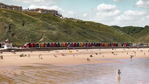 A beach with colorful beach huts and a sandy shore. - Classic Lodges Grinkle Park Easington (Saltburn-by-the-Sea)