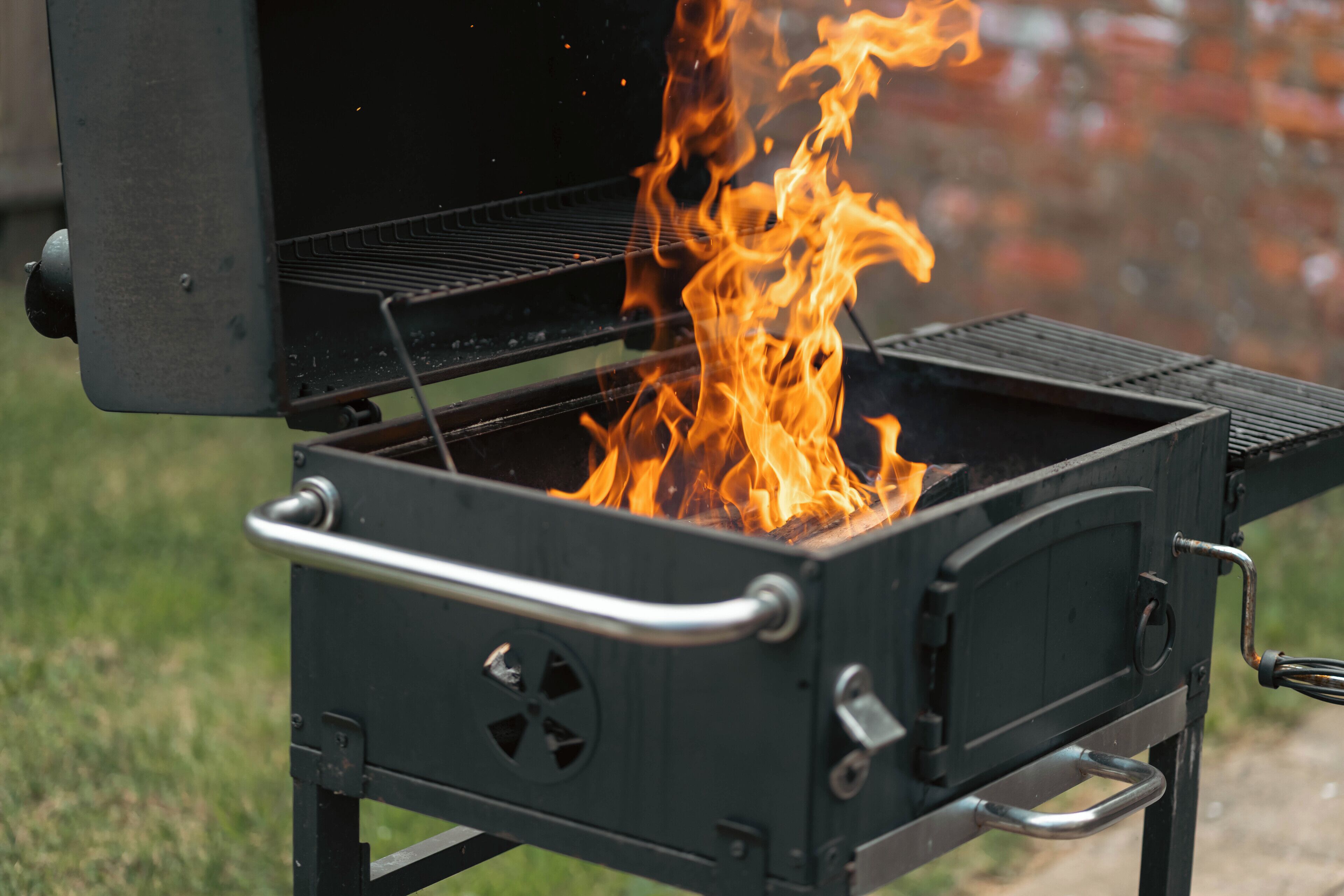 Un barbecue portable doté d’une poignée en métal et d’un bouton de réglage.