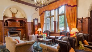 A traditional room with a fireplace, leather sofas, and a patterned carpet. - Classic Lodges Grinkle Park Easington (Saltburn-by-the-Sea)