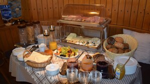 Um buffet com diversos alimentos e utensílios.