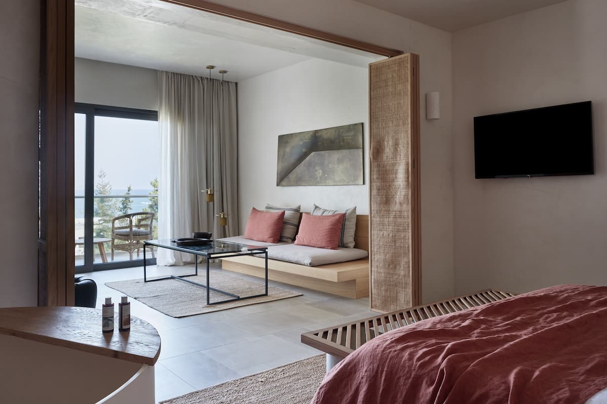 Une chambre moderne avec un grand lit, un canapé, une télévision et un balcon offrant une vue agréable.