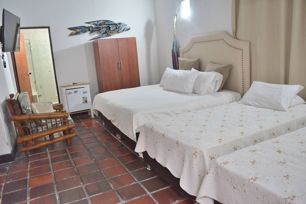 Un dormitorio con dos camas, un armario, una mesita y un espejo.