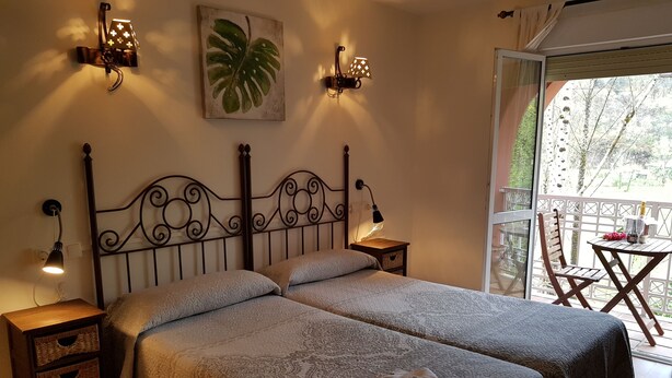 Een slaapkamer met twee bedden, een groot raam en uitzicht op de omgeving.