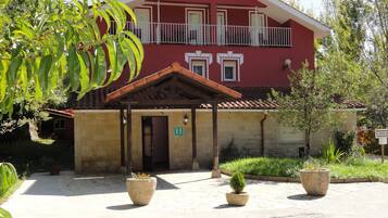 Un edificio rojo con balcón y entrada cubierta.