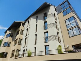 Um edifício de vários andares com varandas, janelas amplas e telhado plano.