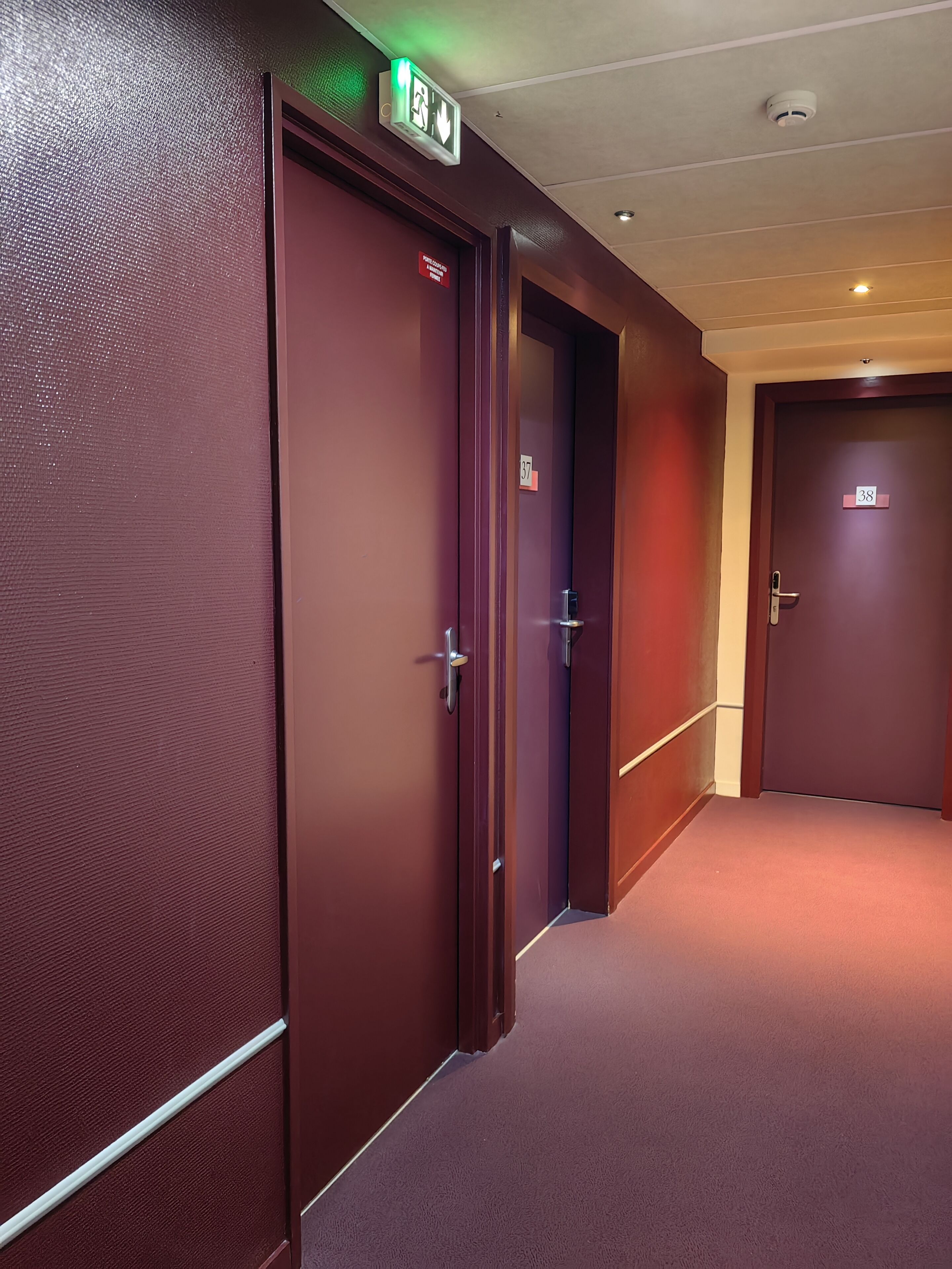 A hallway with three doors, each marked with a number.