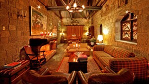A cozy, rustic interior with stone walls, wooden beams, and traditional furnishings. - Hacienda Hato Verde (Latacunga)