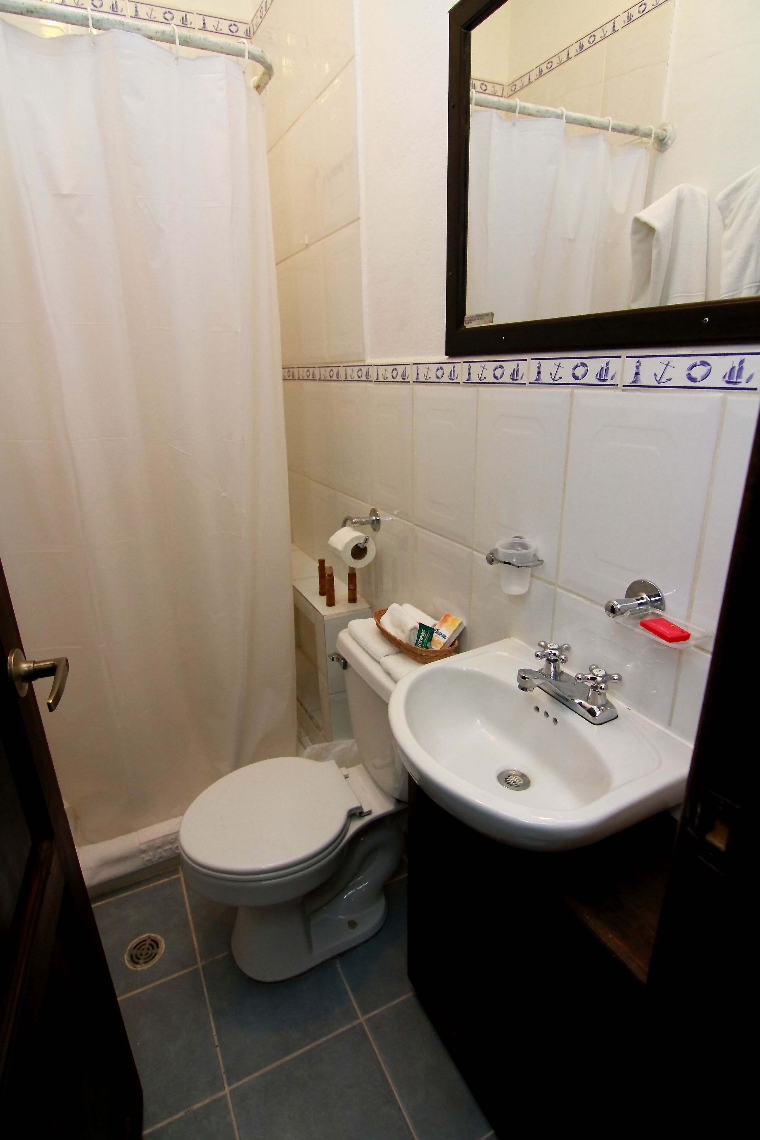 A bathroom with a toilet, sink, and shower curtain.