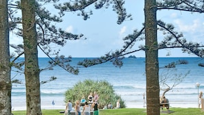 A beachside gathering with people around a bar area, overlooking the ocean. - Bay Motel (Byron Bay)
