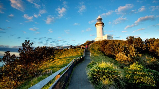 A lighthouse on a grassy hill with a pathway leading to it. - Bay Motel (Byron Bay)