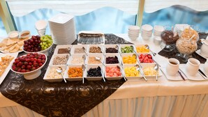 A buffet table with various food items and utensils. - Business Hotel Vega (Wroclaw)