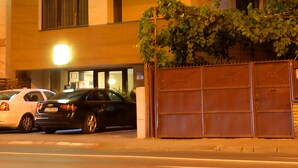 Un hotel con un llamativo letrero que dice "Premier Hotel", varios pisos y una entrada portonada con automóviles estacionados.