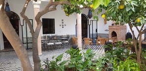Un patio con suelo a cuadros, mobiliario exterior y una fuente.