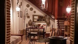 Una sala de estar acogedora con piso estampado, una chimenea, un comedor y una escalera que sube.