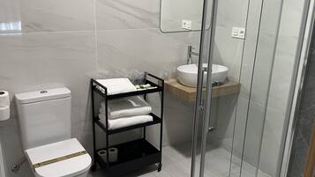A modern bathroom with a toilet, sink, and shower area.
