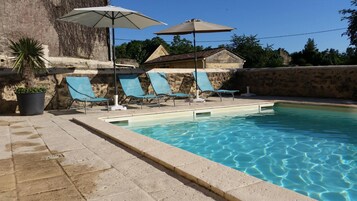 Una piscina al aire libre de temporada, sillones reclinables de piscina