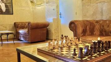 A cozy room with a chessboard, leather sofas, and a door.