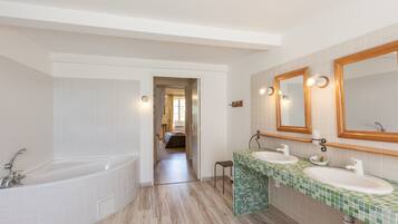 Une salle de bain avec une baignoire, deux lavabos et des miroirs.