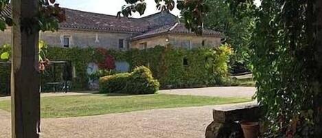 Un patio con un camino de piedra que lleva a un edificio con tejado de tejas.