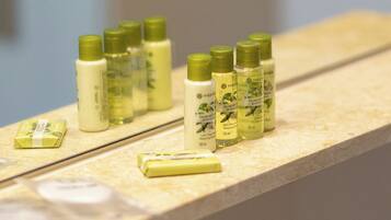 A bathroom counter with several bottles of lotion and a bar of soap.
