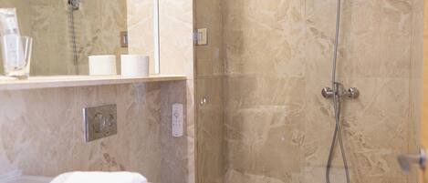 Une salle de bain moderne avec une douche à parois de verre, un lavabo blanc et des toilettes.