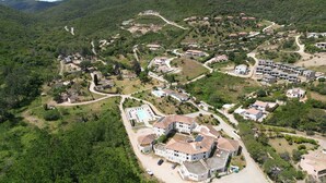 An aerial view of a residential area with houses, winding roads, and a large building with a swimming pool. - Les Pavillons du Golfe (Conca)