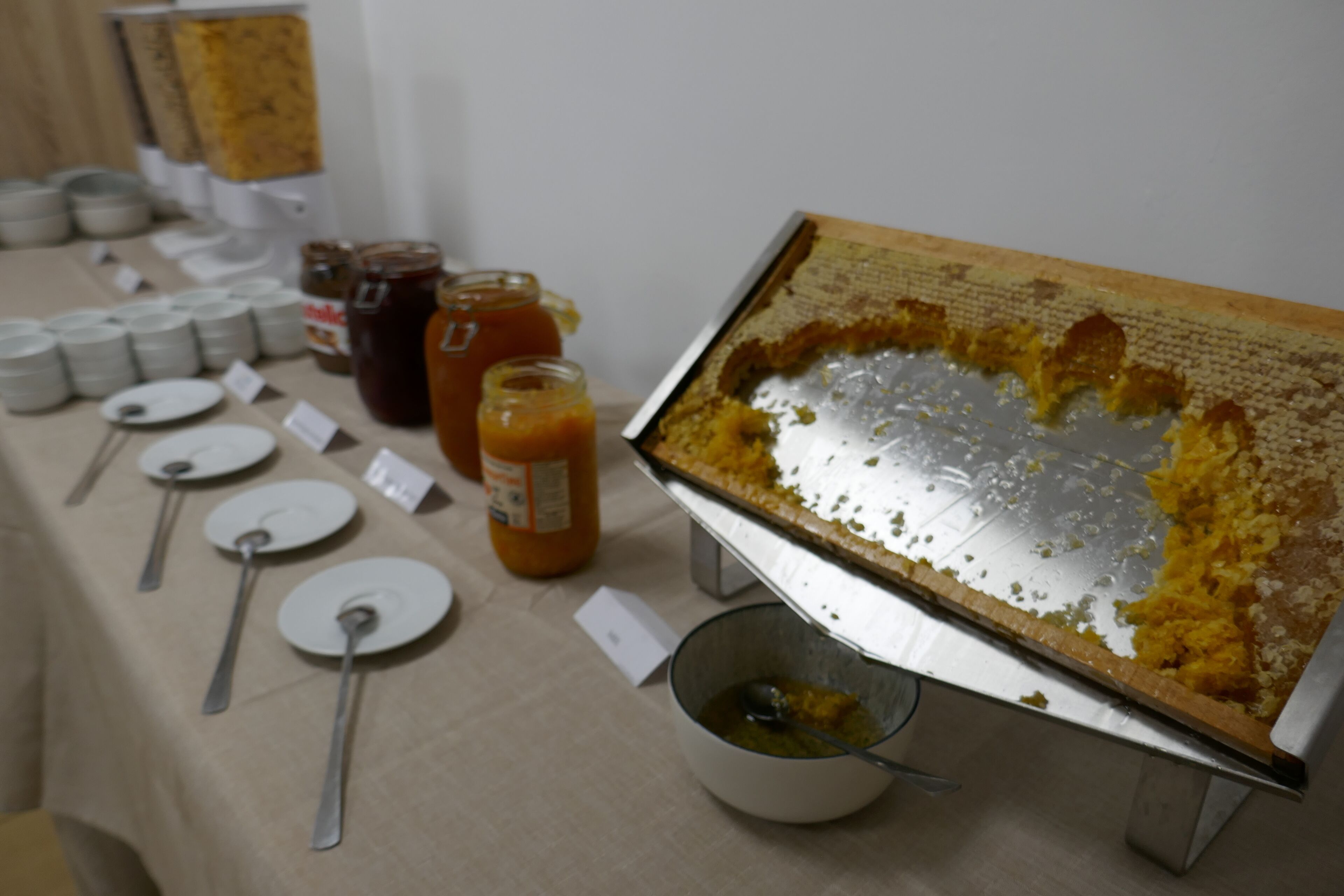 A buffet table with various food items and utensils.