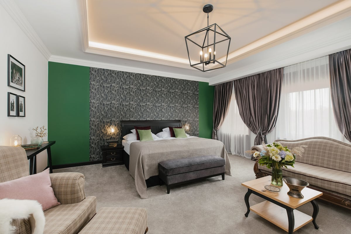 A bedroom with a bed, a sofa, a coffee table, and a nightstand.