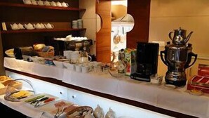 A buffet setup with various food items and kitchen appliances. - Atrium Hotel (Elblag)