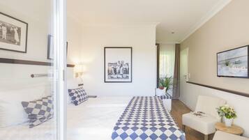 Una habitación de hotel con cama, escritorio, silla y una pequeña mesa con una planta.
